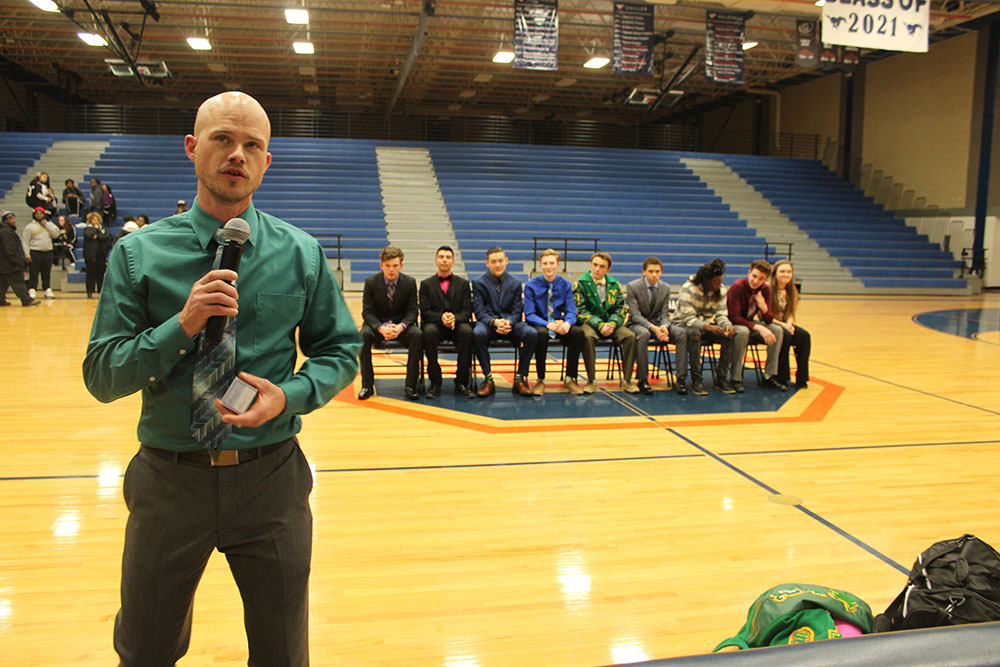 Coach speaks as seated team looks on