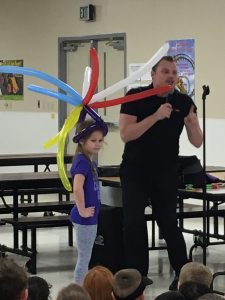 Man speaking, balloon animals, young girl